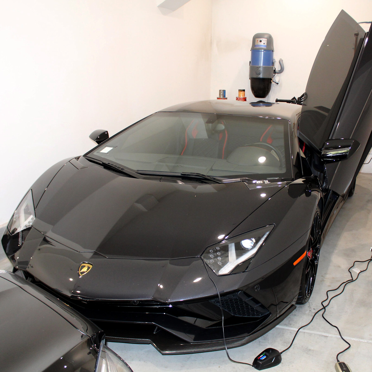Black Lamborghini luxury sports car with open door, symbolizing extravagant purchases linked to corruption